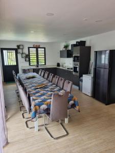 a dining room with a table and chairs and a kitchen at Villa Piton Textor in La Plaine des Palmistes +4 photos