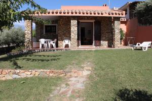 a small stone house with a table and chairs in a yard at Villetta Marino G By La Via Del Mare Viaggi e Vacanze in San Stèfano +32 photos