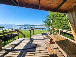 a wooden deck with a bench and a boat on it at Sector 3 de Camping Angostura in Lago Rapel