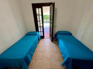 a room with two blue beds and a door at Villetta Marino G By La Via Del Mare Viaggi e Vacanze in San Stèfano
