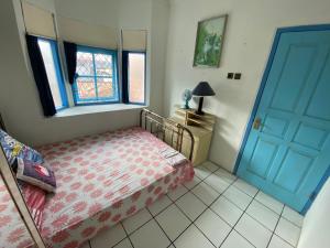 a bedroom with a bed and a blue door at Singgah Macanan in Sentool