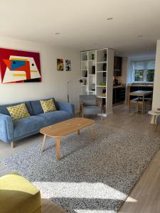 a living room with a blue couch and a coffee table at The Apartment Boscawen Woods in Truro