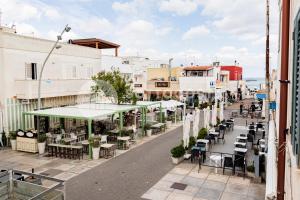 une rue vide avec des tables, des chaises et des bâtiments dans l'établissement CENTRAL SQUARE - San Foca, à San Foca