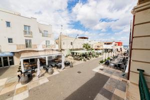 une rue vide avec des tables, des chaises et des bâtiments dans l'établissement CENTRAL SQUARE - San Foca, à San Foca 14 autres photos