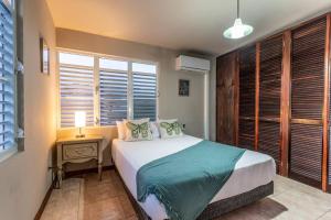 a bedroom with a bed with a night stand and a window at Enjoy Rare Huge POOL 4br Perfect for Families! in Aguada +22 photos