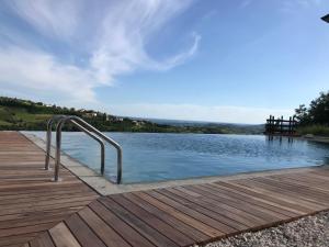 a pool with a metal handrail next to a wooden deck at Enam Room in Kojsko