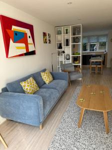 a living room with a blue couch and a table at The Apartment Boscawen Woods in Truro