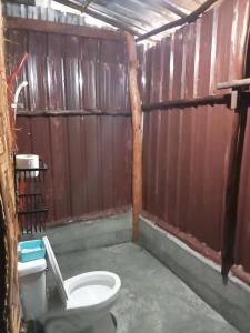 a bathroom with a toilet and a wooden wall at Dahla Lanta Hut in Ko Lanta