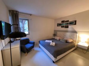 - une chambre avec un lit et une chaise bleue dans l'établissement Appartement T3 8eme Marselle St Anne Proche plage, à Marseille