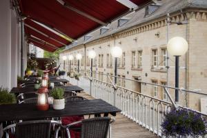 a row of tables and chairs on a balcony at Hotel Kleiner Markt in Saarlouis