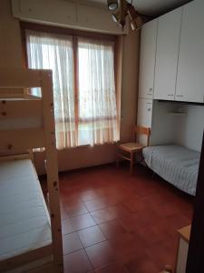 een kleine kamer met een stapelbed en een raam bij Appartamento Conti in San Bartolomeo al Mare