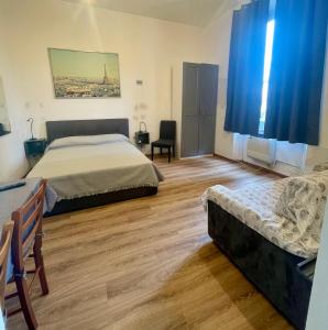 a bedroom with two beds and blue curtains at La Magnolia in Livorno