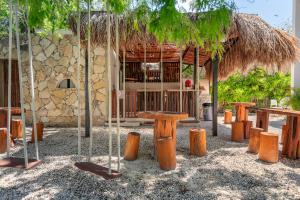 a building with a hut with a table and benches at Xhule Tulum in Tulum