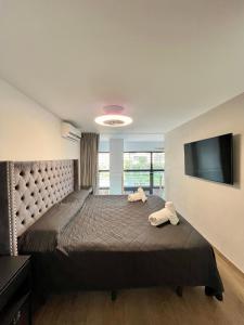 a bedroom with a large bed and a flat screen tv at WeRentVLC - Espectacular Duplex Terraza y Piscina in Valencia
