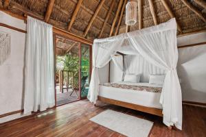 a bedroom with a bed with a canopy at Xhule Tulum in Tulum +34 photos