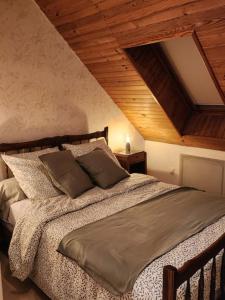 a bedroom with a large bed with a wooden ceiling at Appartement à la campagne in Bournainville