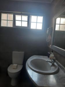 a bathroom with a white toilet and a sink at Casa vicente in Santa Cruz das Flores