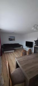 a living room with a wooden table and chairs at Ferienwohnung für bis zu 10 Personen in Koetz 