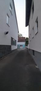 an alley between two white buildings with a garage at Ferienwohnung für bis zu 10 Personen in Koetz 