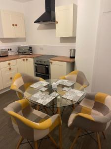 a kitchen with a glass table and four chairs at Skegness Town Centre Apartment 2 in Skegness