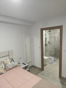 a bedroom with a bed and a bathroom with a shower at Pension Casa Pedro in Fisterra +38 photos