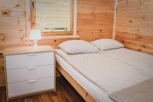 a bed in a tiny house with a lamp on it at Ranczo Tropical Sun Mielenko in Mielenko +1 photo