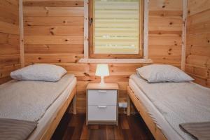 a bedroom with two beds in a wooden cabin at Ranczo Tropical Sun Mielenko in Mielenko