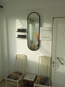 a mirror on a wall with two chairs and a table at Denise Villa in Platánion