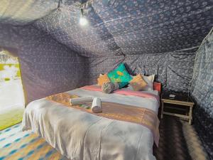 a bedroom with a bed in a room with wallpaper at Tyakshi Summer Camp in Turtok