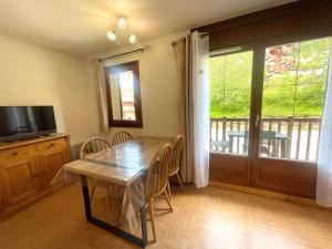 Telewizja i/lub zestaw kina domowego w obiekcie Appartement cosy au pied des pistes avec piscine, balcon et parking privé - FR-1-505-170