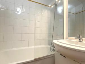 biała łazienka z umywalką i prysznicem w obiekcie Appartement cosy au pied des pistes avec piscine, balcon et parking privé - FR-1-505-170 w mieście Flumet