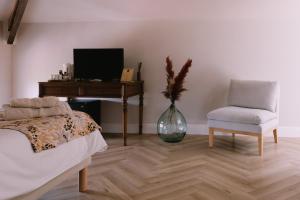 a bedroom with a bed and a desk and a chair at L'Orangeraie d'Afa in Afa