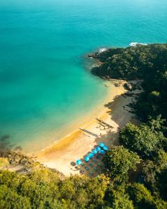 una vista aérea de una playa con sombrillas azules en Buzios Mar Hotel & Spa en Búzios