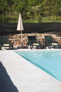 een groep stoelen en een parasol naast een zwembad bij Holiday Home “Vuko” in Trilj