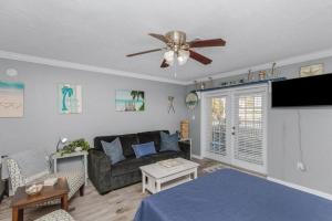 a living room with a couch and a ceiling fan at Our Happy Place in Fort Walton Beach