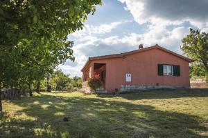a small house in a field next to a yard at Holiday Home “Vuko” in Trilj