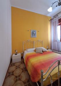 Un dormitorio con una cama y una pared amarilla. en Casa Meraki - Appartamento in centro, en Avola