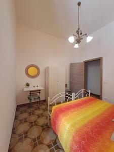Un dormitorio con una cama colorida y una mesa en Casa Meraki - Appartamento in centro, en Avola