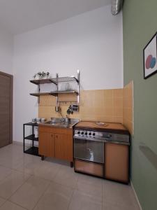 una cocina con fregadero y estufa en Casa Meraki - Appartamento in centro, en Avola 6 fotos más