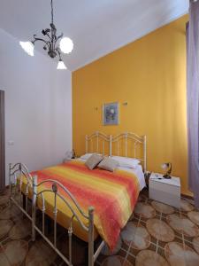 Un dormitorio con una cama y una pared amarilla. en Casa Meraki - Appartamento in centro, en Avola