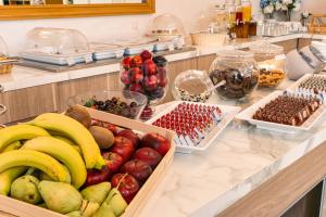 a buffet with bananas apples and other fruits in baskets at Danae Hotel in Egina