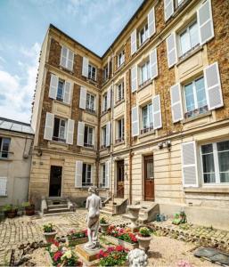 pomnik przed dużym budynkiem w obiekcie Lovely Apartment Palace of Versailles w Wersalu