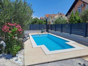 a swimming pool in a backyard with a fence at Villa Carpe diem in Vodice