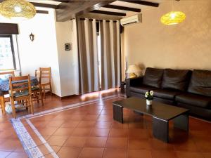 uma sala de estar com um sofá e uma mesa em Squash Club Apartamentos em Portimão