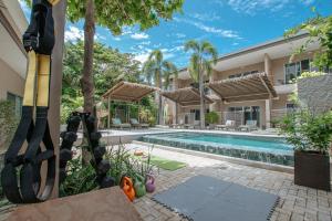 an exterior view of a villa with a swimming pool at Tamarindo Bay Boutique Hotel, Apartments & Suites in Tamarindo