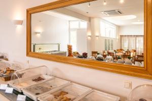 a mirror on a wall with trays of food at Danae Hotel in Egina