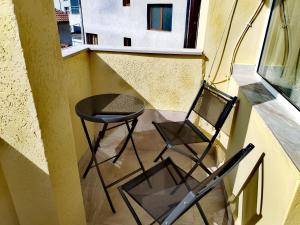 a balcony with a chair and a table and a window at Стаи за гости Гергана град Созопол in Sozopol +34 photos