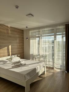 a bedroom with a large bed and a large window at Modern House in Solotvyno