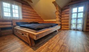 een slaapkamer met een bed in een blokhut bij Relax Srub Kunějov in Člunek