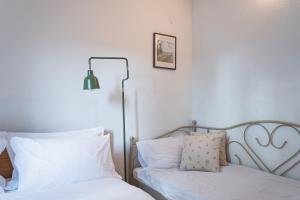 a bedroom with two beds with white sheets and a lamp at Holiday Home “Vuko” in Trilj +33 photos
